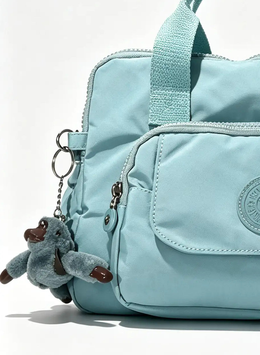Sky Blue Handbag with Large Front Pocket & Animal Charm | شنطة يد أزرق سماوي بجيب أمامي واسع وميدالية حيوان
